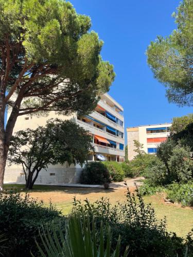 弗雷瑞斯Frejus Plage - 50m2 au calme, tout à pieds的一座大楼，前面有一棵树