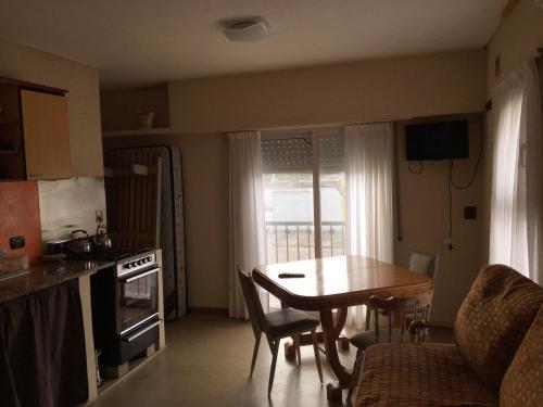 a kitchen and dining room with a table and a table and chairs at Alquiler Temporario Olavarría in Olavarría