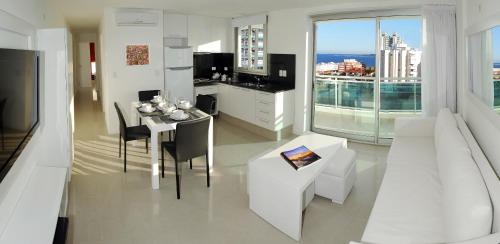 a white kitchen with a table and a dining room at Categoría, excelente ubicación y full amenities! in Punta del Este