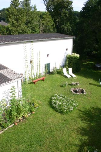 un patio con un edificio blanco y algunas plantas en Ferienhaus Rehblick, en Rockeskyll