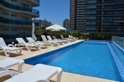 a pool with chaise lounge chairs and a swimming pool at Categoría, excelente ubicación y full amenities! in Punta del Este