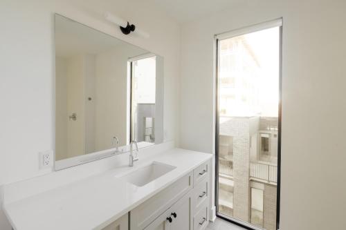 un bagno bianco con lavandino e grande specchio di Sonder The High Note a Nashville