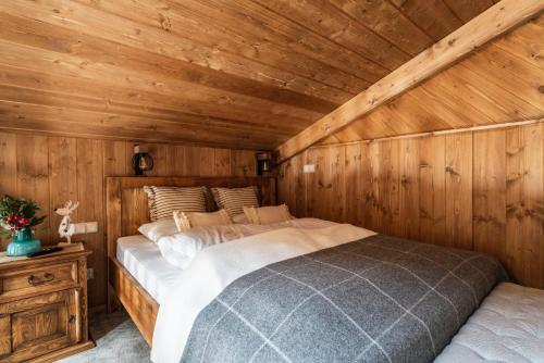 een slaapkamer met een bed in een houten hut bij Górska Antresola in Zakopane
