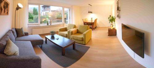 ein Wohnzimmer mit Sofa, Sesseln und Fernseher in der Unterkunft Ferienwohnung Eschenberg in Winterberg