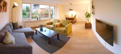 a living room with a couch and chairs and a tv at Ferienwohnung Eschenberg in Winterberg