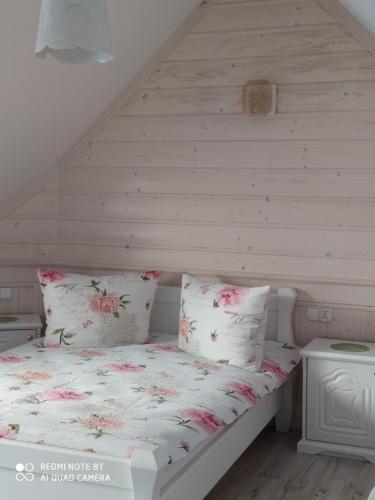 a bed with pink flowers on it in a attic at Domek Fafik in Krościenko