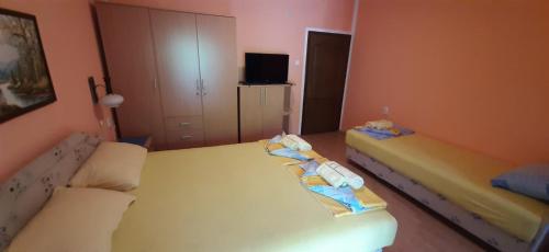 a bedroom with two beds and a tv in it at Studios Milošev in Bar