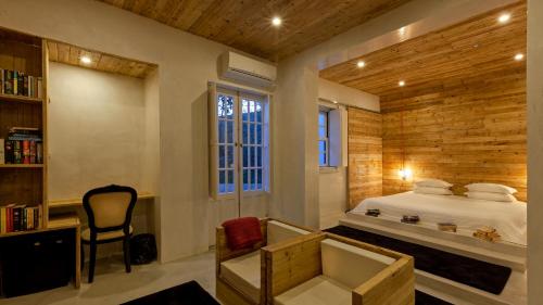1 dormitorio con cama, escritorio y silla en The Literary Man Obidos Hotel, en Óbidos