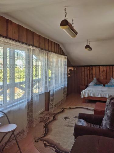 a living room with a bed and a couch at Приват-котедж Зарінок in Mykulychyn