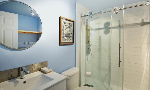 a bathroom with a shower and a sink and a mirror at 76.5 Chemin de la Perdrix in Stoneham