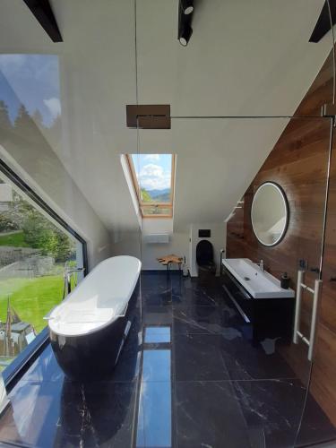 a bathroom with a tub and a sink and a mirror at Dom Minimal House in Szczyrk