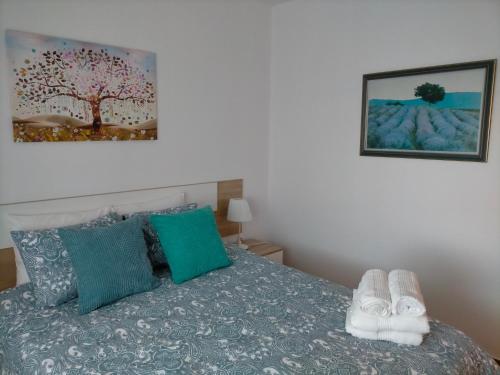 um quarto com uma cama com almofadas verdes e azuis em Casa Zawadi em Mijas