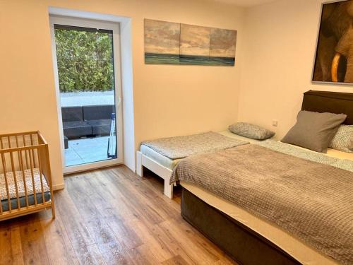 a bedroom with two beds and a sliding glass door at Apartments bei Playmobil EG,130m2 in Zirndorf