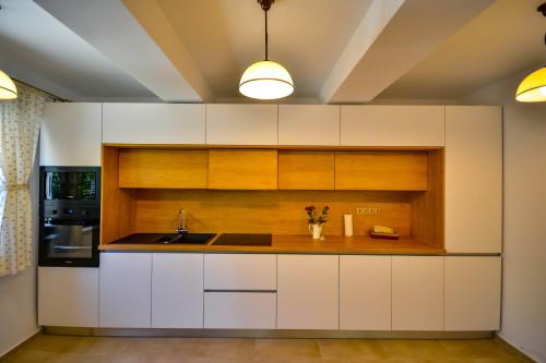 a kitchen with white cabinets and a sink at Casa Mora in Deva