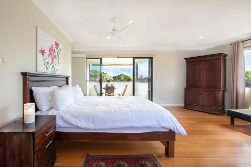um quarto com uma cama grande e uma varanda em Oceania Peace em Yamba