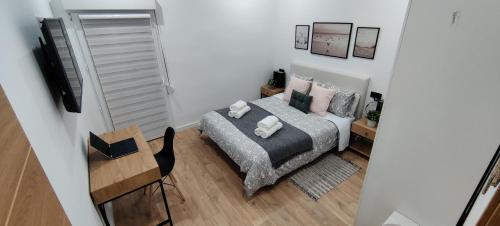 a small white bedroom with a bed and a table at New Apartment Claret in Xàtiva
