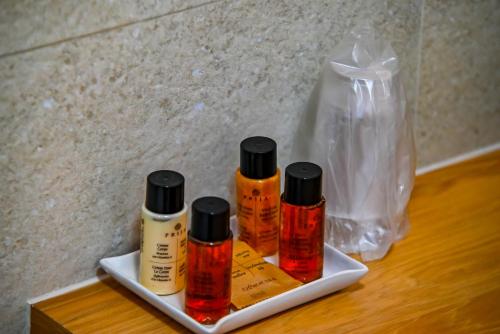 three bottles of essential oils on a plate with a plastic bag at Casa Mora in Deva