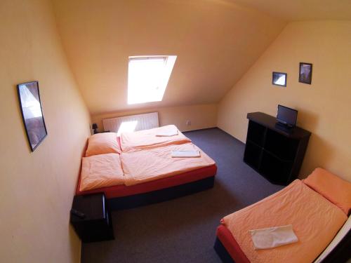 a small room with two beds and a television at Restaurace penzion Rafael in Dlouhá Brtnice