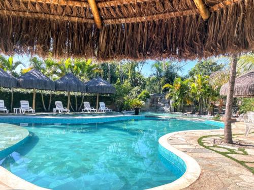 una piscina in un resort con sedie e ombrelloni di Villa Triacca Hotel Vinícola & Spa a Brasilia