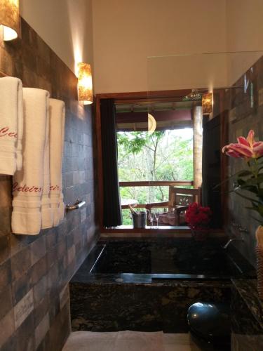 a bathroom with a sink and a window and towels at Pousada Celeiro do Gutto in Cunha