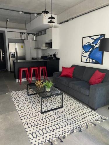 a living room with a couch and red chairs at Moderno Apto Shift Zona 16, cerca de Embajada EEUU y Explanada Cayala in Guatemala