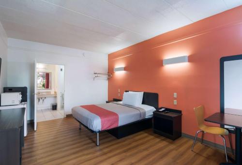 a bedroom with a bed and a desk and a tv at Motel 6-Seaford, DE in Seaford