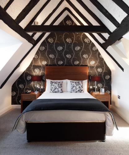 a bedroom with a large bed in a attic at The Boleyn Hotel in Staines