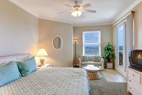 um quarto com uma cama, uma ventoinha de tecto e uma televisão em Ocean Place II em Fernandina Beach