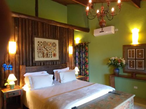 a bedroom with a large bed with green walls at Pousada Celeiro do Gutto in Cunha