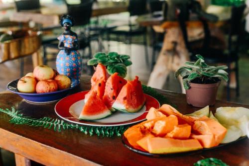 a table with two plates of fruit on them at Pousada Cantinho de Casa in Nobres
