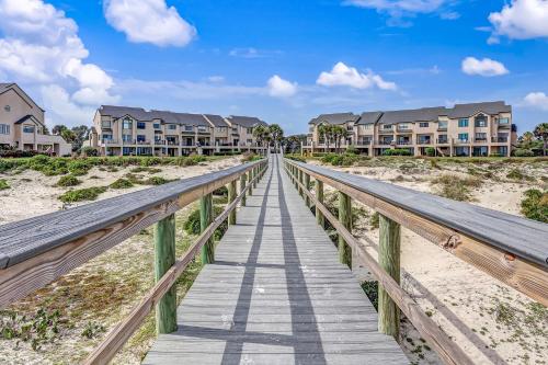 a boardwalk over the sand at the beach with condos at Sailmaker in Fernandina Beach