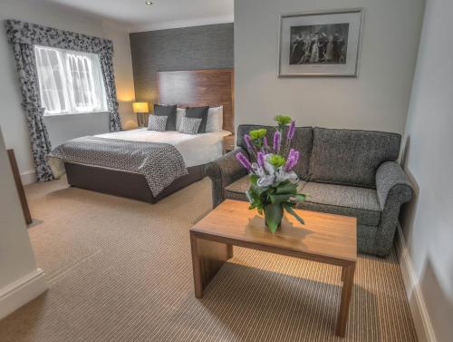 a living room with a couch and a bed at The Boleyn Hotel in Staines