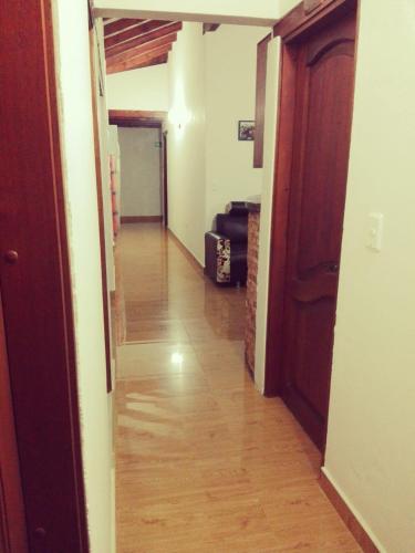 an empty hallway with a wooden floor and a door at Hospederia Sandaned in Villa de Leyva