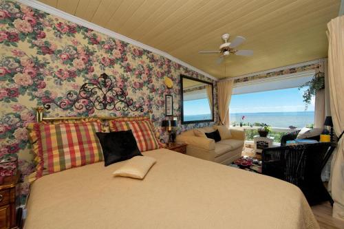 a bedroom with a bed with a floral wall at Maison Victoria in La Malbaie