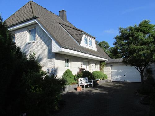 a white house with a garage and a driveway at Pension Roseneck in Wolfshagen