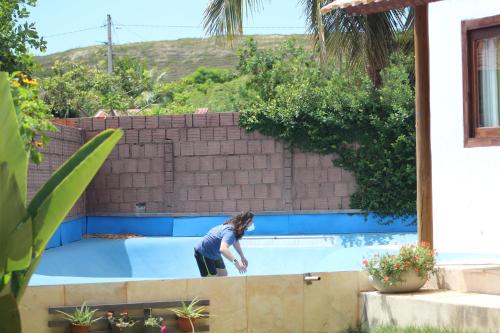 a woman is standing in a swimming pool at Casa Mar Taíba in São Gonçalo do Amarante