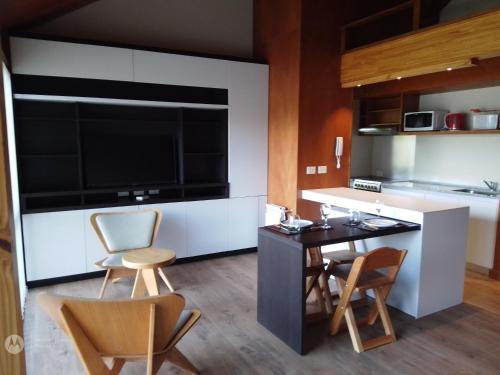 cocina con mesa y sillas y TV grande en EDIFICIO VIVERo 3, en San Martín de los Andes