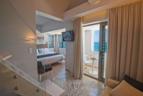 a hotel room with a bed and a view of the ocean at Swell Boutique Hotel in Rethymno Town
