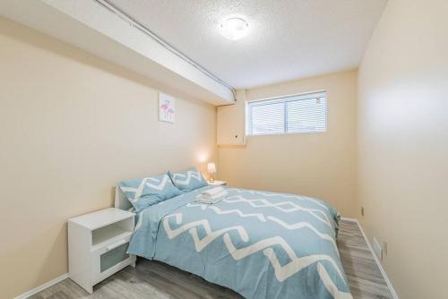 1 dormitorio con 1 cama con colcha azul y blanca en MT Pleasant NW 2 bedrooms Suite 500AB, en Calgary