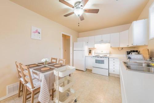 cocina con mesa y ventilador de techo en MT Pleasant NW 2 bedrooms 500, en Calgary