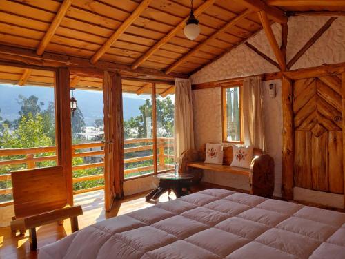 ein Schlafzimmer mit einem großen Bett und einem Balkon in der Unterkunft ATALLARO Hospedaje in Otavalo