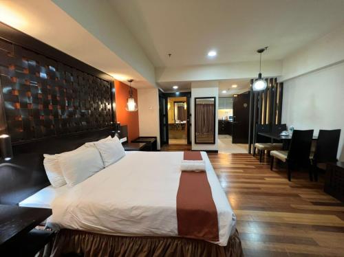 a hotel room with a bed and a dining room at Raintree Resort Suites in Petaling Jaya