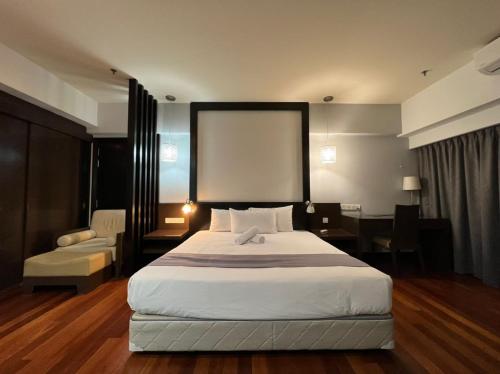 a hotel room with a bed and a desk and a chair at Raintree Resort Suites in Petaling Jaya