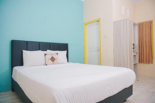 1 dormitorio con 1 cama blanca grande en una habitación en GRAND KHALIFAH Guesthouse, en Sumbawa Besar