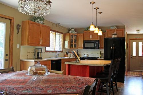 eine Küche mit einem Tisch und einem schwarzen Kühlschrank in der Unterkunft MellowOut B&B in Lions Head