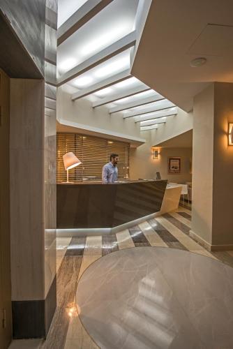 a man standing at a counter in a lobby at Swell Boutique Hotel in Rethymno Town