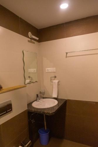 a bathroom with a sink and a mirror at ComfyCorner - Luxurious 2-BHK Apartment in Arpora