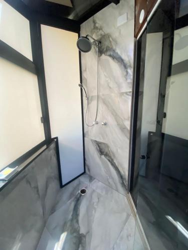 a bathroom with a shower with a marble floor at FIKA Residence in Dois Irmãos