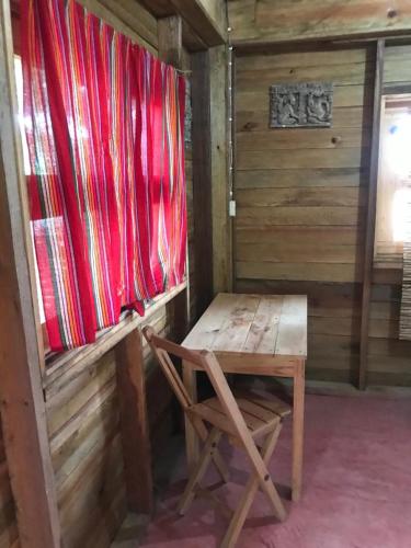 a wooden room with a wooden table and a bench at Cabañas Toniná Kayab in Ocosingo