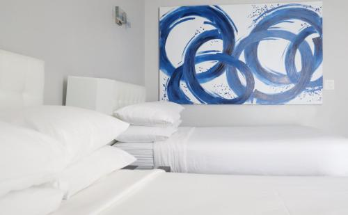 a pile of pillows and a painting on a wall at Park Plaza Lodge in Los Angeles
